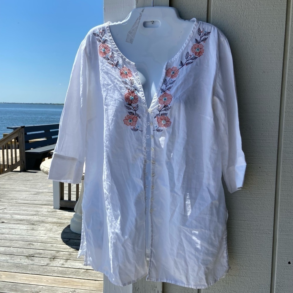This NY & Co white cotton shirt has embroidered flowers with French not centers.